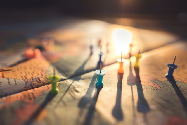 different coloured push pins on a map