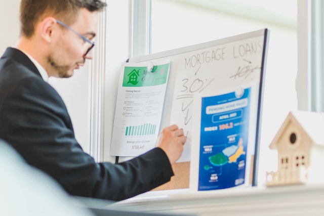 mortgage lender writing notes and percentages on a whiteboard