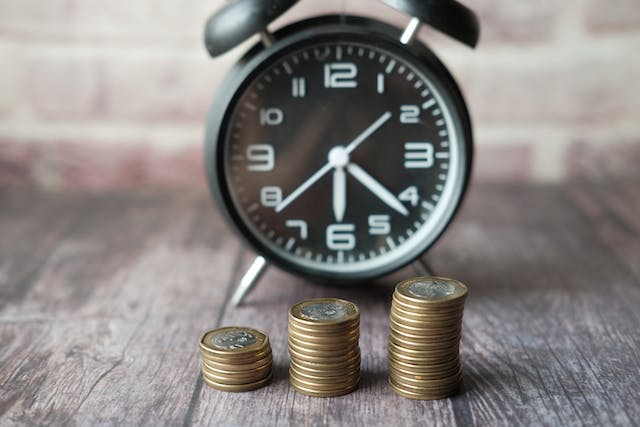 stacks-of-coins-in-front-of-an-alarm-clock