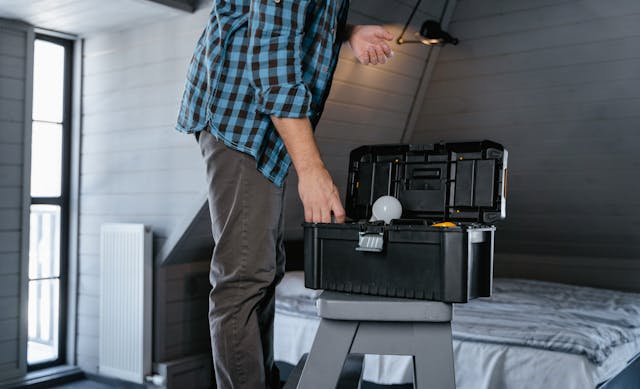 person-standing-in-front-of-a-tool-box-sitting-on-a-ladder.