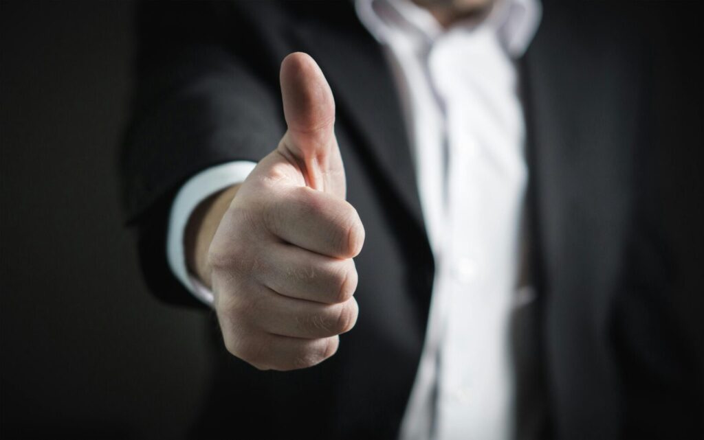 man in a suit giving a thumbs up